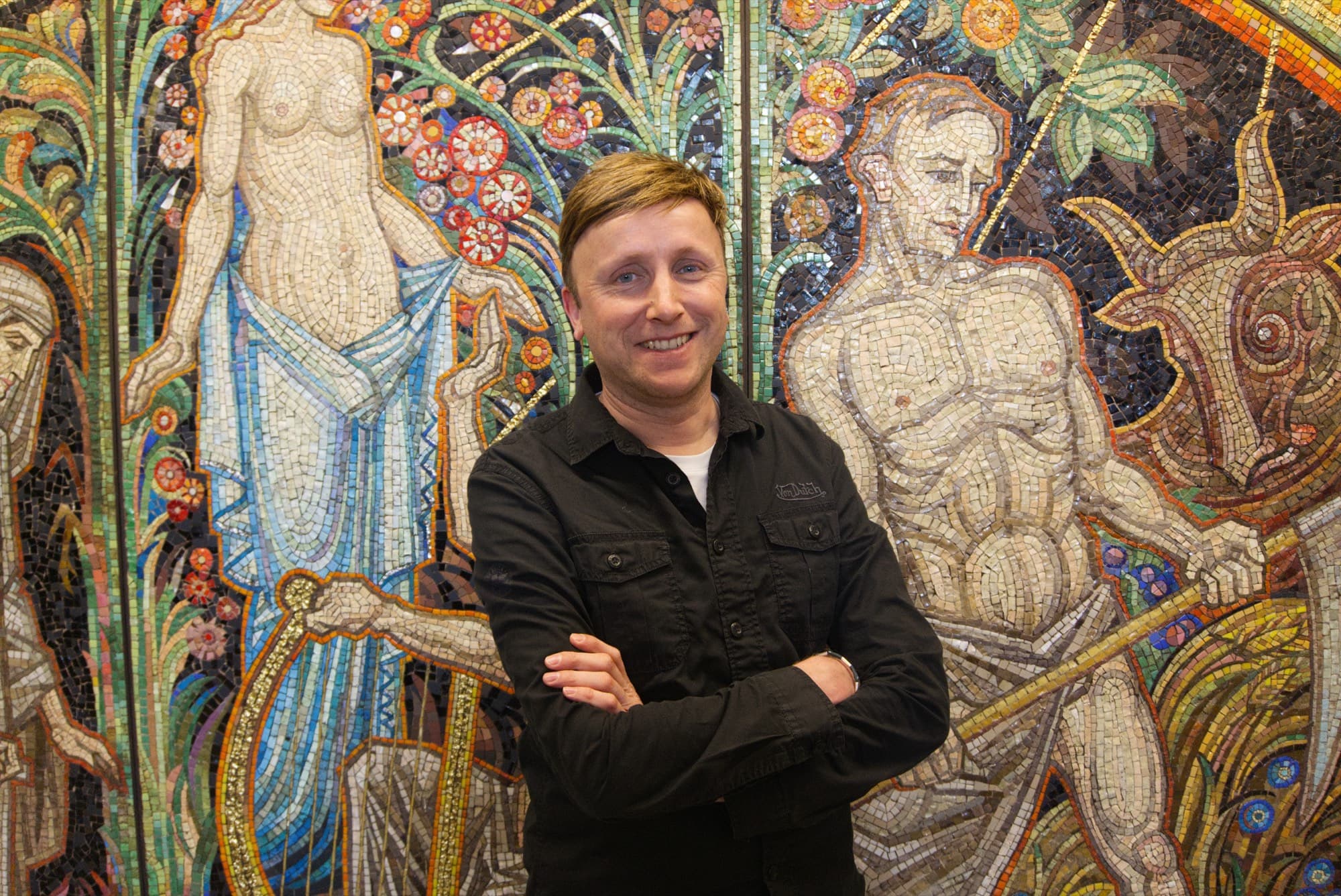 Johan van der Gaag in front of a mosaic at his school